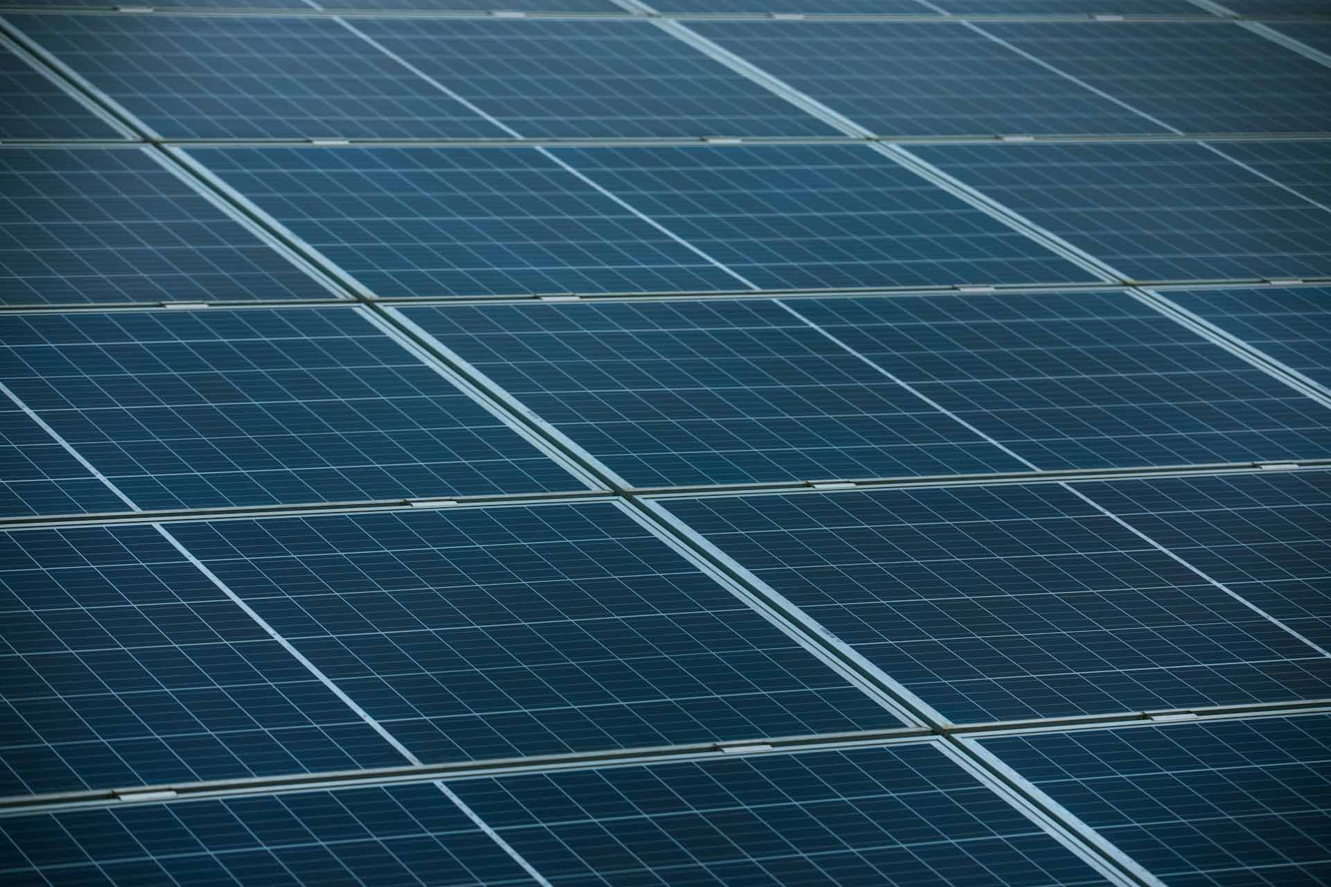 Close-up view of blue photovoltaic solar panel modules showing grid pattern and panel frames